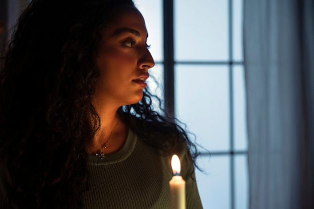 Free photo side view woman holding lit candle