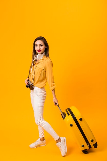 Free photo side view of woman holding luggage with copy space