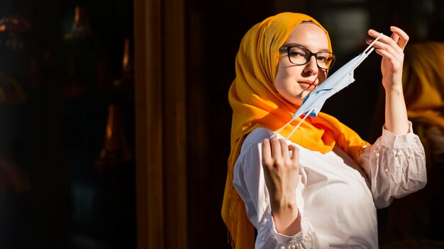 Side view woman holding medical mask