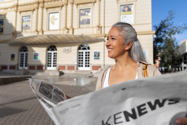 Side view woman holding newspaper