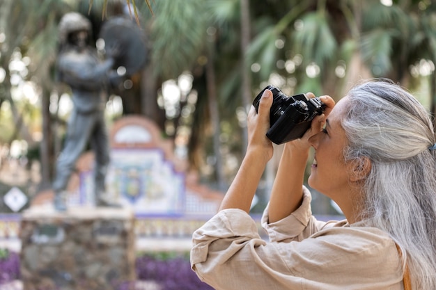 Side view woman holding photo camera