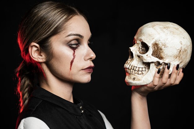 Side view of woman holding skull