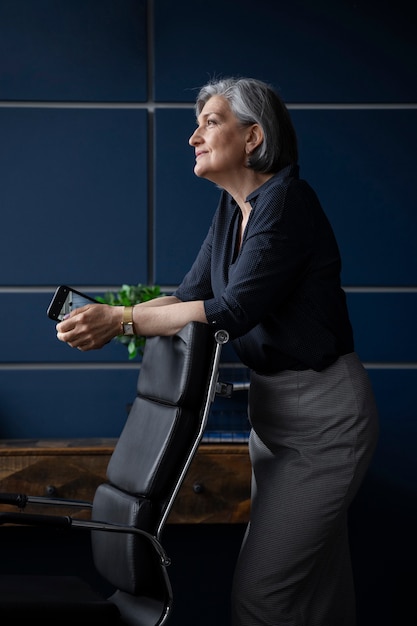 Free photo side view woman holding smartphone