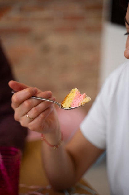 Foto gratuita cucchiaio della tenuta della donna di vista laterale con la torta