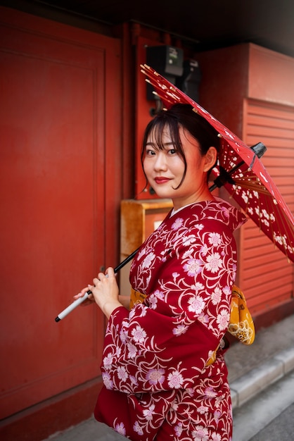 Free photo side view woman holding wagasa umbrella