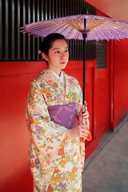 Free photo side view woman holding wagasa umbrella