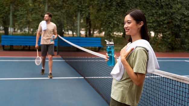 Free photo side view woman holding water bottle