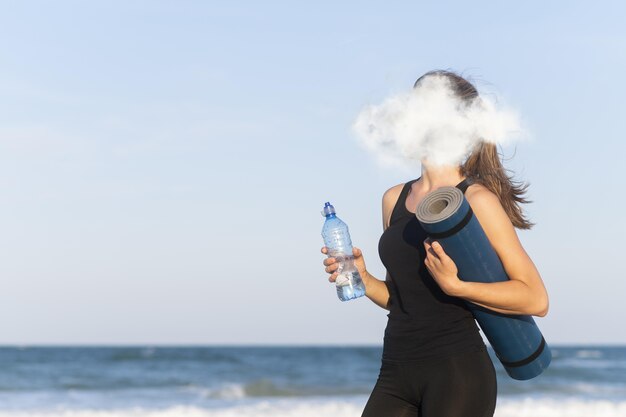 Side view woman holding yoga mat