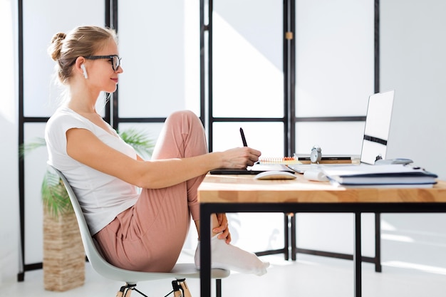 Side view of woman at home desk working