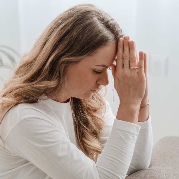 Side view of woman at home praying