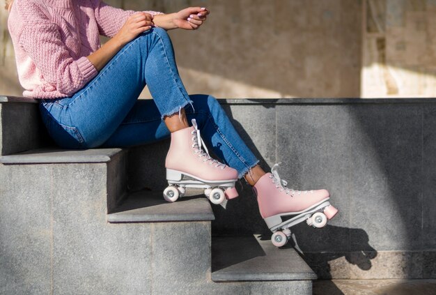 Side view of woman in jeans on stairs with roller skates