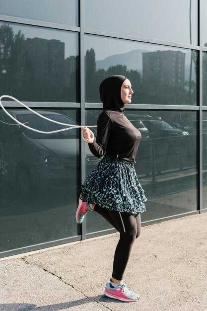 Side view of woman jumping rope