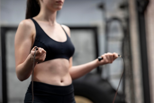 Free photo side view of woman jumping rope