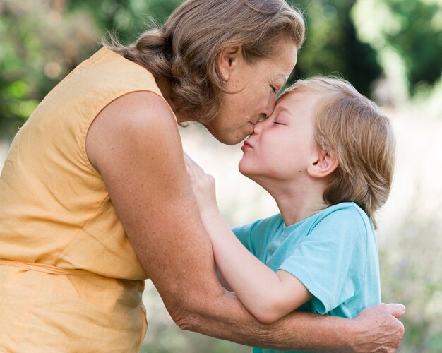 Вид сбоку женщина целует внука