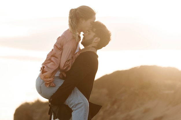 Side view woman kissing man on forehead