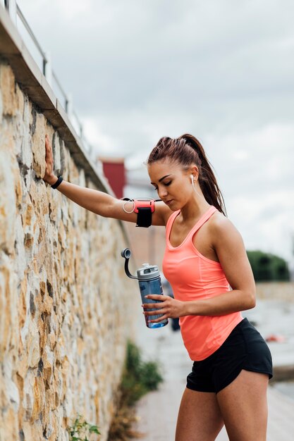 Side view of woman leaning on wall