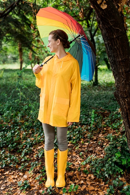 Side view woman looking away while holding an umbrella