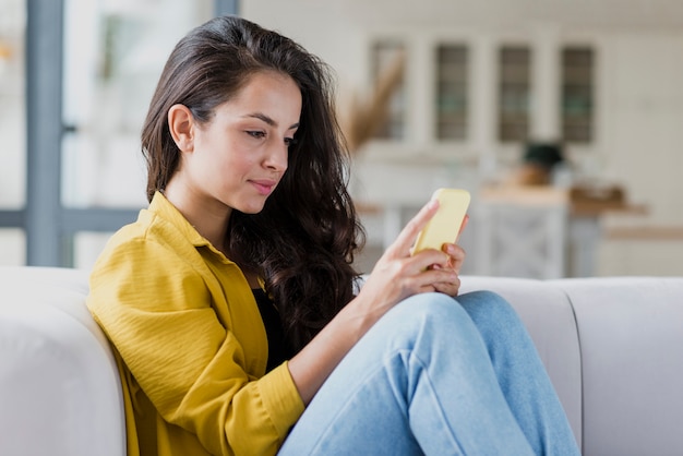 Side view woman looking at smartphone