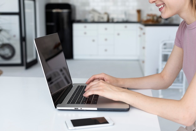 Side view woman looking through her laptop