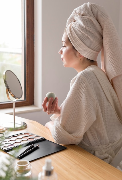 Side view woman make up with sponge