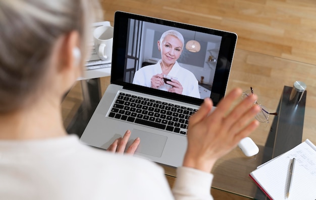 Free photo side view woman making a video call