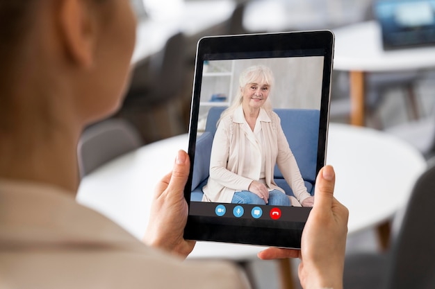 Free photo side view woman making a video call