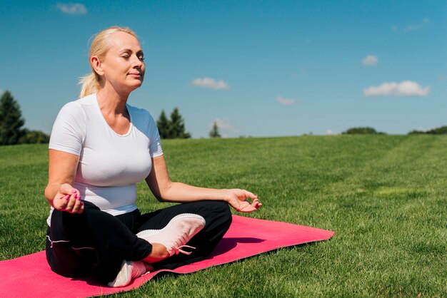 Side view woman meditating in nature