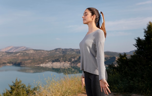 Side view woman meditating in nature