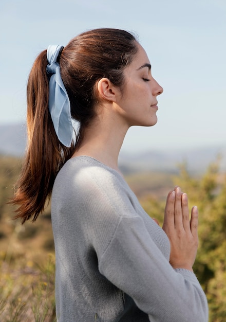Side view woman meditating in nature