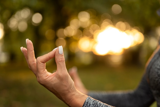 Free photo side view woman meditating outdoors