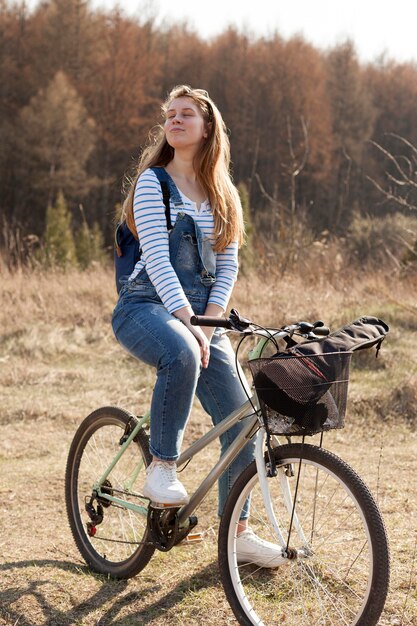 Взгляд со стороны женщины в природе представляя на велосипеде