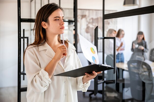 Side view woman at office with clipboard