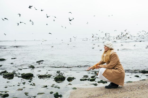 Side view of woman outdoors at the beach in winter