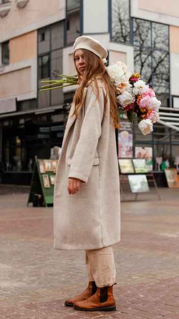 Side view of woman outdoors holding bouquet of flowers in the spring