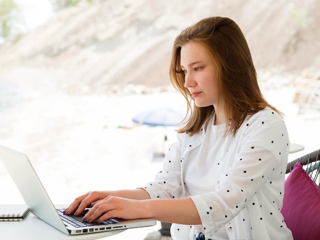 Foto gratuita vista laterale della donna che lavora all'aperto al computer portatile