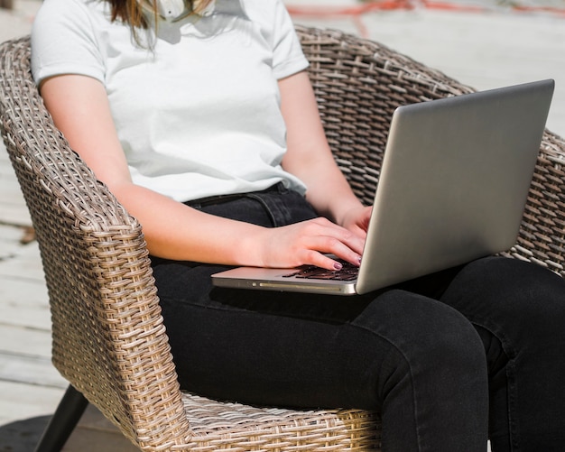 Вид сбоку женщины на улице работает на ноутбуке