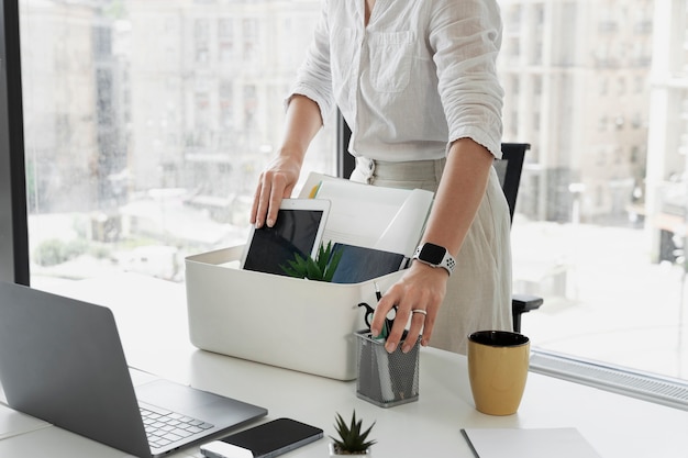 Side view woman packing desk items