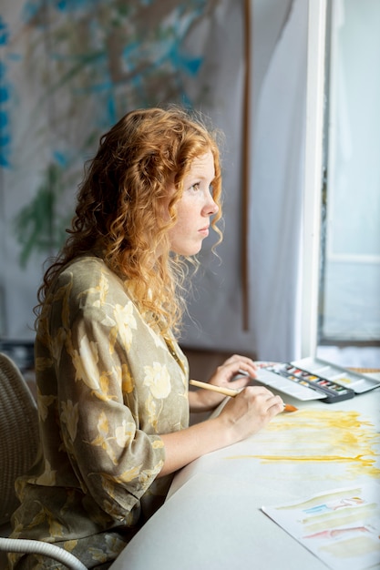 Side view woman painting indoors