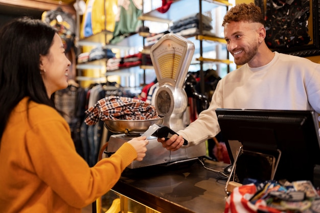 Free photo side view woman paying with card