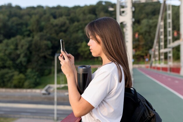 一人で旅行しながら景色を撮影する女性の側面図