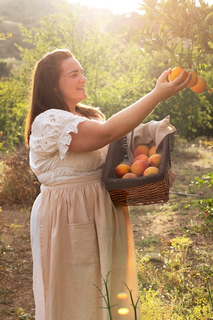 Side view woman picking fruits