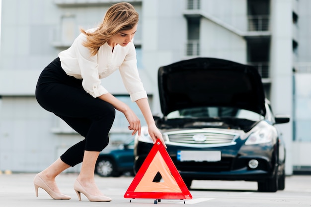 Free photo side view of woman placing emergency sign