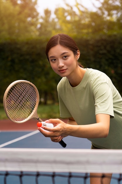 Side view woman playing badminton