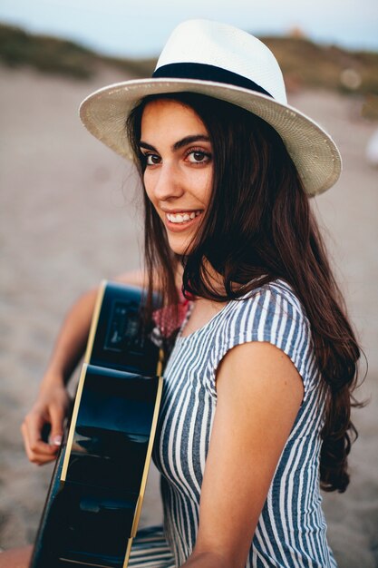 Side view of woman playing the guitar at the beach