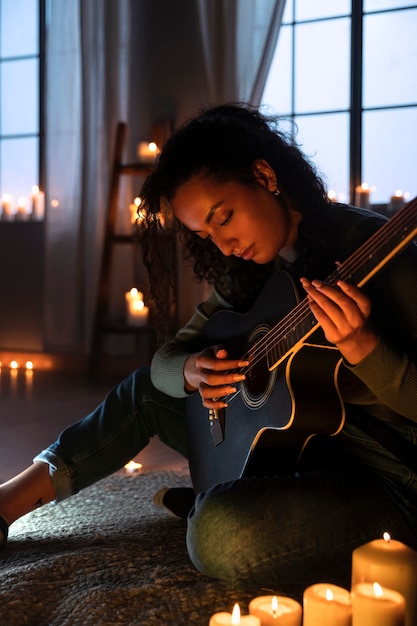 side view woman playing guitar at home