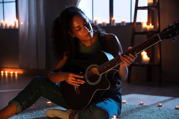 side view woman playing the guitar