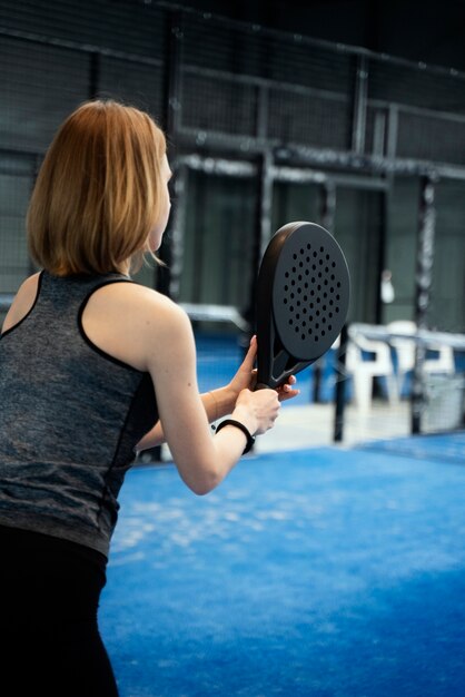 Side view woman playing paddle tennis