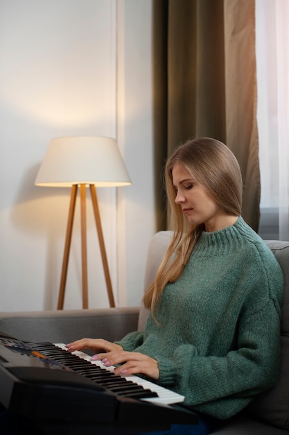 Free photo side view woman playing piano