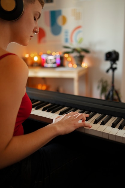 Free photo side view woman playing the piano