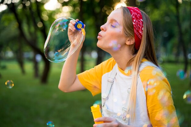 Side view of woman playing with bubbles